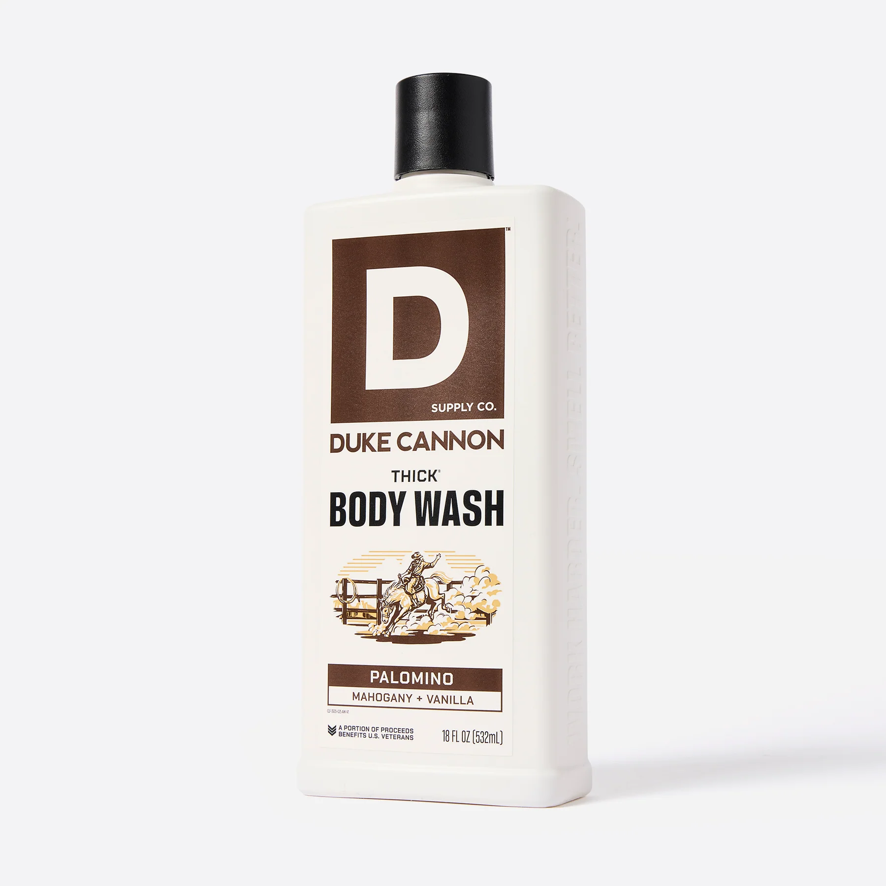 A white, rectangular bottle of DUKE CANNON THICK BODY WASH with a black cap, shown from the front against a grey background. Label featuring the logo, product name and a cowboy on a rearing Palomino. ‘Mahogany + Vanilla’, 532 ml.