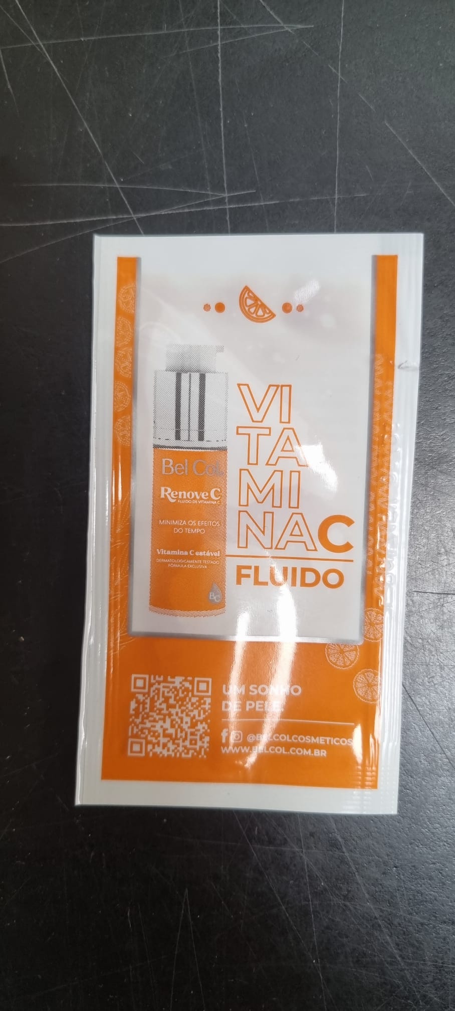 Weiß-oranges Bel Col RenoveC Fluid Sachet mit Aufschrift "Vitamina C Fluido". Bewirbt ein Vitamin-C-Serum, das Zeichen der Zeit mindert, stabil und dermatologisch getestet ist, exklusive Formel zur direkten Hautversorgung.