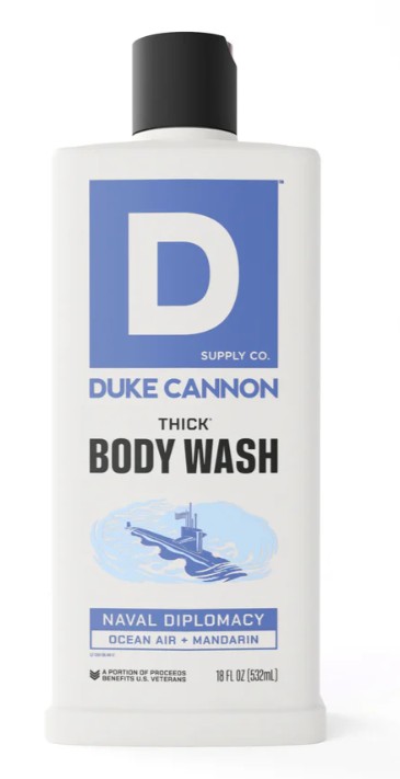 White, rectangular bottle of DUKE CANNON Thick Body Wash “Naval Diplomacy” with a black flip-top cap. Blue label featuring a large “D”, the brand name and product type. Submarine on waves, “Ocean Air + Mandarin” fragrance. 532 ml.