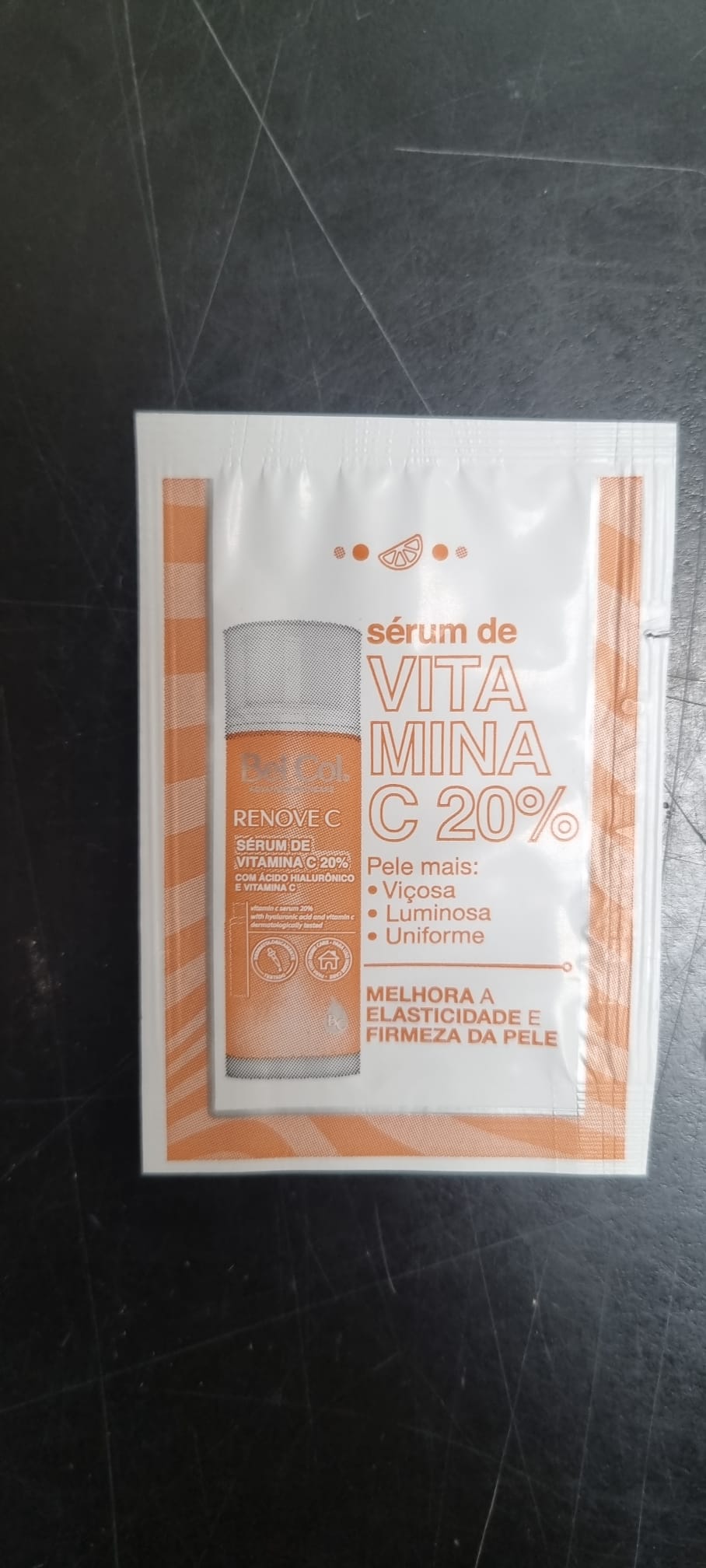 Un sachet d'échantillon du sérum BelCol Renove C sur fond sombre. L'emballage blanc et orange représente un flacon contenant un sérum à 20 % de vitamine C qui revitalise la peau, unifie le teint, hydrate et améliore l'élasticité.